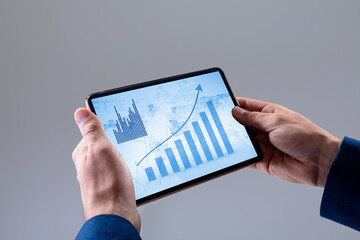 Poster - Hands of caucasian businessman using tablet, with graphs on blue interface screen
