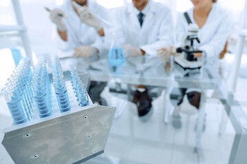 Wall Mural - background image of scientists studying blue liquid in a flask