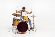 Portrait Of Emotive, Expressive Man In Sunglasses Playing Drums, Performing Isolated Over White Background