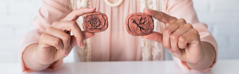 Wall Mural - cropped view of fortune teller holding clay runes while predicting at home, banner.