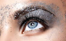 Close Up Face Detail In Studio Light. Female Natural Blue Eye With Beautiful Glitter Smokey Eyes Stage Makeup. Festive Bright Makeup.