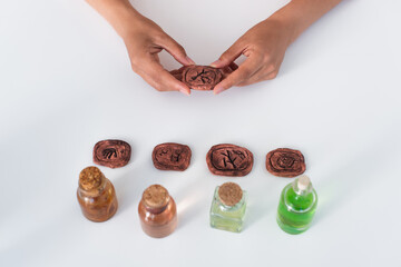 Wall Mural - top view of partial fortune teller holding clay rune near jars with essential oils.