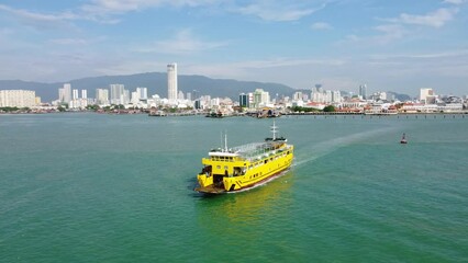 Wall Mural - Penang, Malaysia: Aerial drone footage of the RORO car ferry leaving George Town in Penang island for Butterworth in Malaysia. Shot with a forward motion 