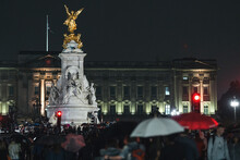 People Mourn And Bring Flowers Under The Rain Outside Buckingham Palace After Queen Elizabeth Died