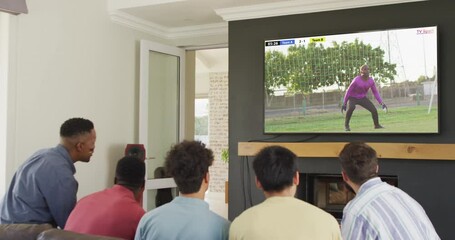 Canvas Print - Video of diverse friends sitting on sofa and watching football on television at home