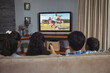 © vectorfusionart - Happy latin family watching football match siting together on the couch