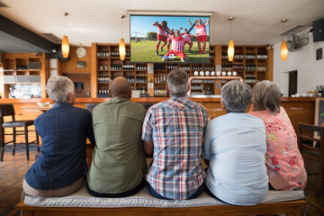 Poster - Group of senior people watching football match siting together in bar