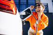 © Petro - Woman charging electric car by her house