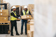 © Jacob Lund - Cheerful warehouse workers storing cardboard boxes onto a pallet truck