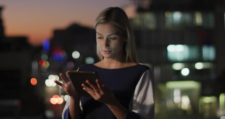 Wall Mural - Video of thoughtful caucasian businesswoman using tablet at night in office