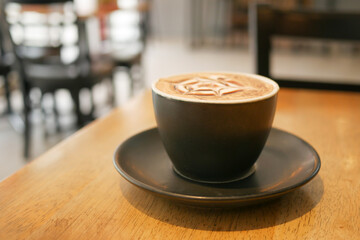 a cup of late coffee with flower shape design on top at cafe 