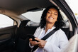 © kleberpicui - Happy businesswoman using smartphone in the car
