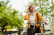 © Drobot Dean - Grey asian woman with headphones standing by her bicycle at park