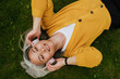 © Drobot Dean - Grey asian woman smiling while lying on grass in summer park