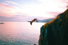Woman Jumping Into Ocean