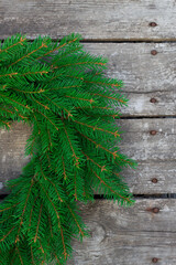 vertical image of wreath with christmas tree branches on wooden background