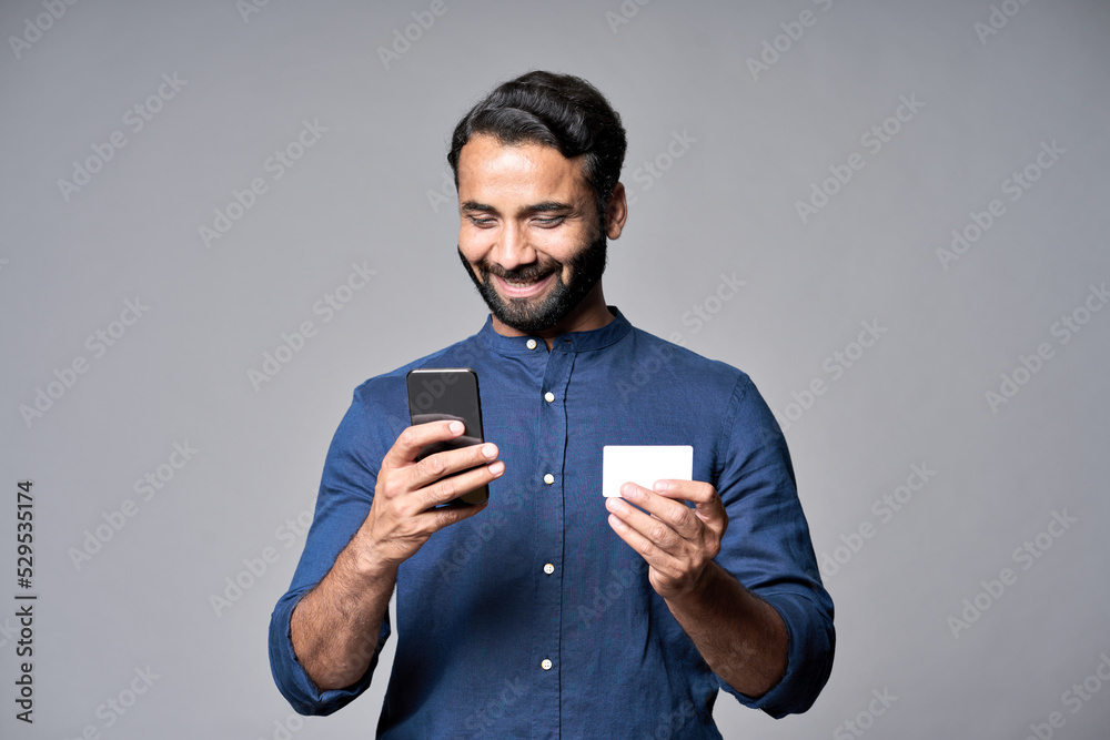 Happy indian business man holding smartphone and credit card using cell ...