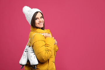 Poster - Happy woman with ice skates on pink background. Space for text