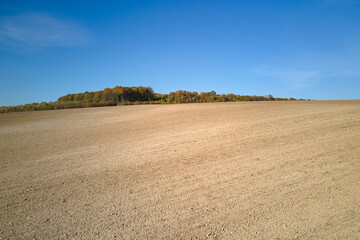 Plowed agricultural field with cultivated fertile soil prepared for planting crops in spring