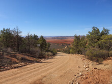 Dirt Road Leading Down Hill To Brown Plains
