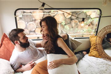 Wall Mural - Young beautiful loving couple travelling across country in the van. Millennial man and woman in a travel camper. Cozy atmosphere, vacations vibe