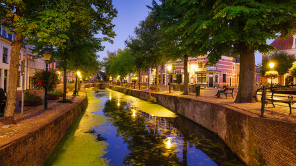 Wall Mural - Architecture in the Netherlands. Modern and old buildings. Canals and bridges. Architectural landscape. Evening lighting in the city. Postcard view.