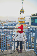 Wall Mural - little girl enjoying view to Parisian skyline with roofs