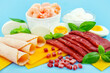 Proteinreiche Ernährung mit Fleisch, Käse, Ei, Joghurt und Shrimps auf blauem Hintergrund