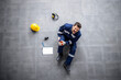 © littlewolf1989 - Top view of an injured factory worker having knee pain due to the fall. Safety at work first.