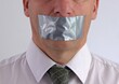Businessman with duct tape over mouth