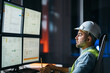© leonidkos - Bearded operator of factory control industry process using monitors. Engineer follow on production line