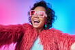 © gstockstudio - Beautiful African woman in trendy clothes making selfie and smiling against colorful background