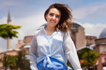 European girl in a blue skirt on the background of a mosque. photo session of a girl on the background of hagia sophia in istanbul. photo of a tourist in istanbul against the backdrop of attractions