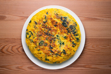 Wall Mural - Spinach and potato omelette. Traditional Spanish tortilla recipe. Top view shot.