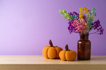 Wall Mural - Autumn dried flowers and pumpkin decoration on wooden table over purple background. Thanksgiving greeting card