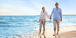 © Pixel-Shot - Happy mature couple walking on sea beach