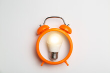 Light Bulb With Alarm Clock On White Background. Concept Of Idea