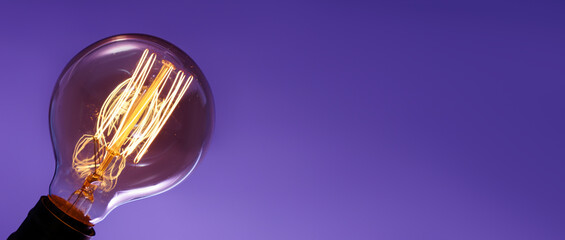 Wall Mural - Glowing light bulb on color background with space for text, closeup