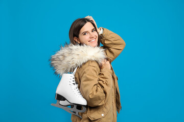 Sticker - Happy woman with ice skates on light blue background