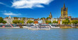 Cologne, Germany - July 9. 2022: Beautiful panoramic rhine river skyline, St. Martin church, cruise ships, colorful medieval waterfront houses