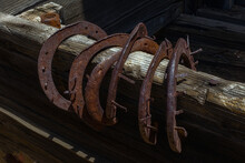 Old Rusty Horseshoes On A Wooden Rail