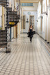 © lara-sh - Beautiful girl in black dress running in hall checkered floor. High quality photo