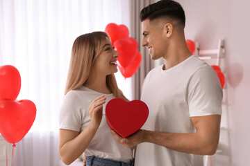 Poster - Lovely couple with gift in room. Valentine's day celebration