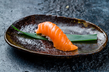 Wall Mural - sushi salmon on a plate on dark stone table