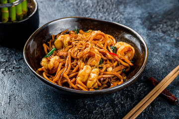 Wall Mural - egg noodles with shrimps on dark stone table, Chinese cuisine