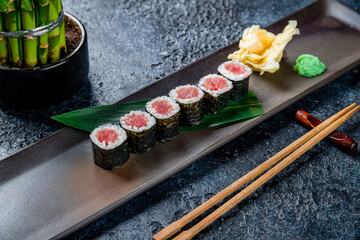 Canvas Print - roll with tuna maki on dark plate on dark stone table