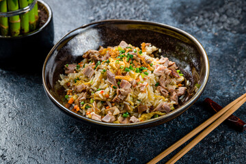 Canvas Print - fried rice with duck on dark stone table