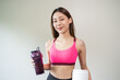 © Pormezz - young sporty girl holding protein shake isolated on background