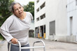 old senior woman with back pain using walking frame or walking aid device, concept of aging society health care, thin bone, osteoporosis or osteoarthritis symptom