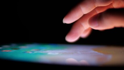 Man's hands and fingers are writing touches on the tablet screen.